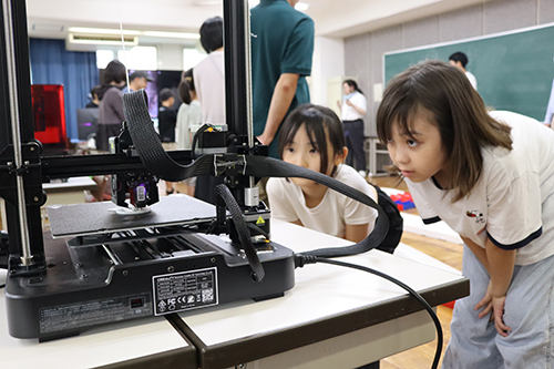 3Dプリンターを見つめる参加者
